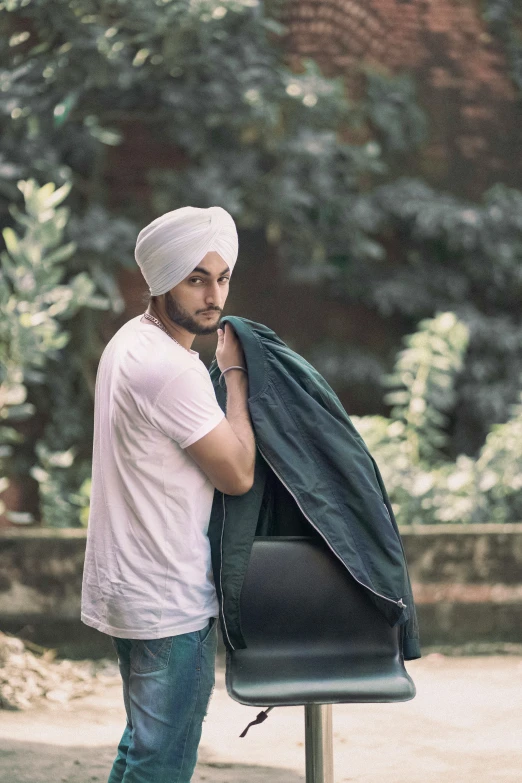 a young man is putting on his jacket while standing on the side walk