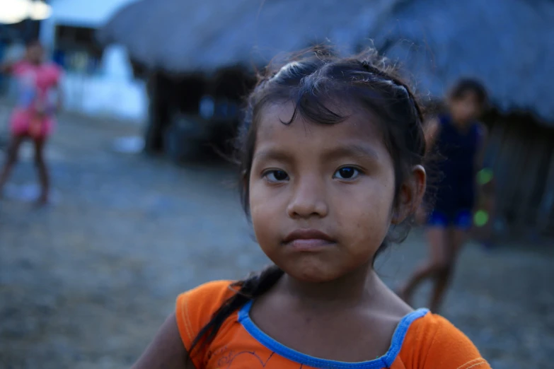 a small girl standing outside in front of huts