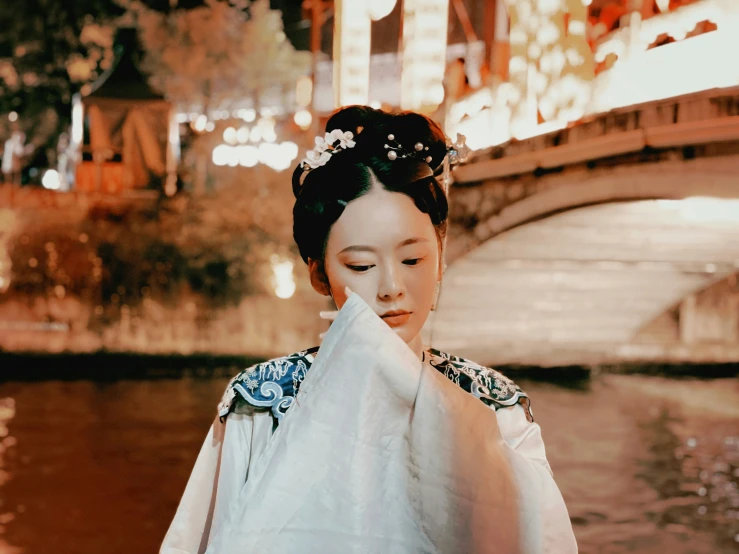 a geisha girl is standing near the water