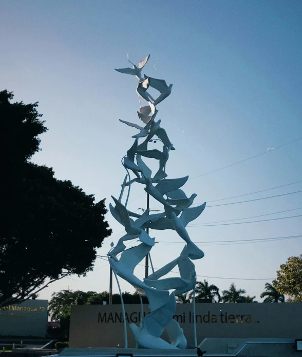 a statue with a bird in the center and a tree next to it