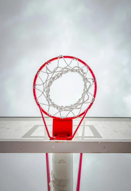 a red basketball in the hoop of a basketball court