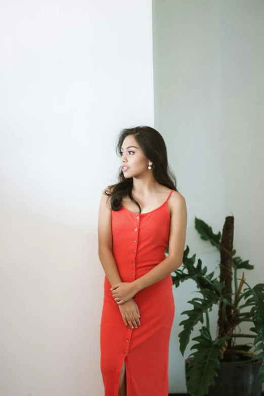 woman in long red dress with one leg hanging out looking away