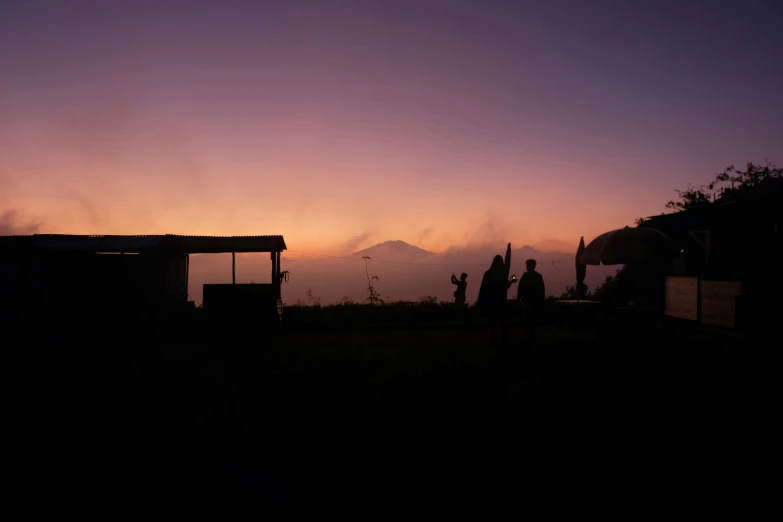 two people watching the sun go down with a purple background