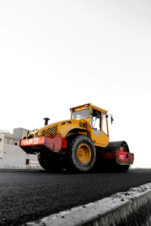 a yellow bulldozer truck sits in a parking lot