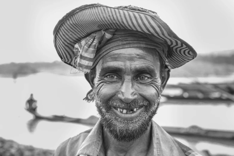 a man smiling at the camera with his hat on