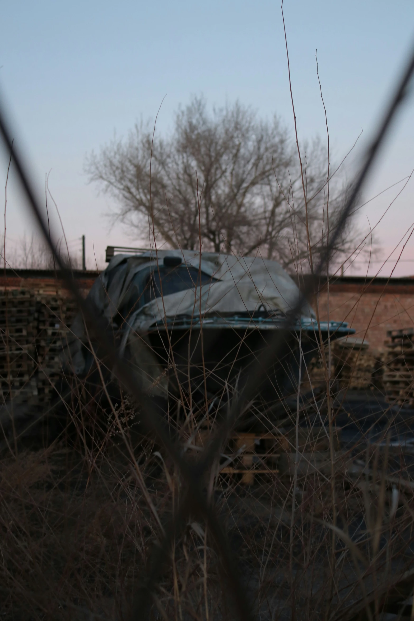 a run down building sits by the fence in winter