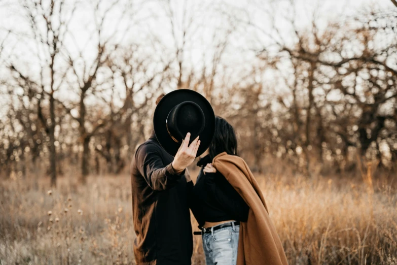 the guy and girl are standing in a field