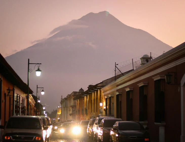 cars are parked in front of the mountains during the evening