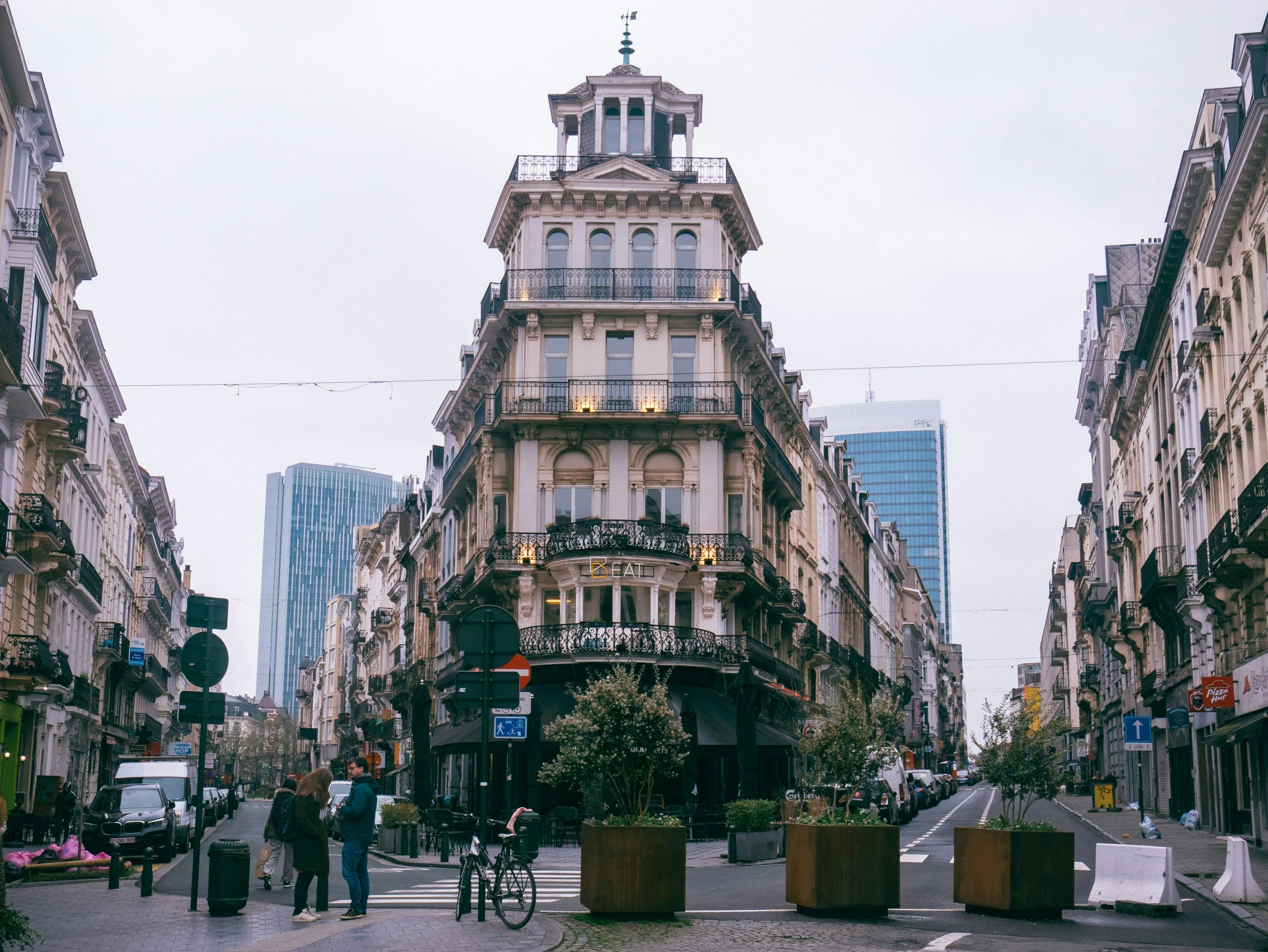 a city street with lots of tall buildings and some pedestrians