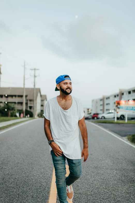 a man with a blue hat standing on a street