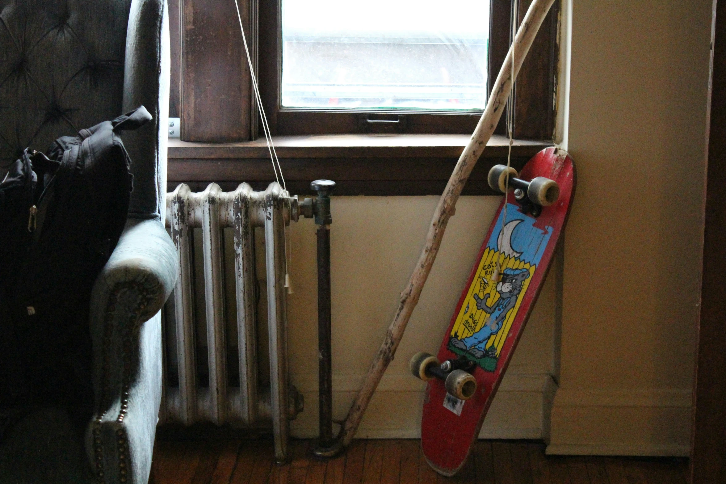 a skateboard rests in front of an old radiator