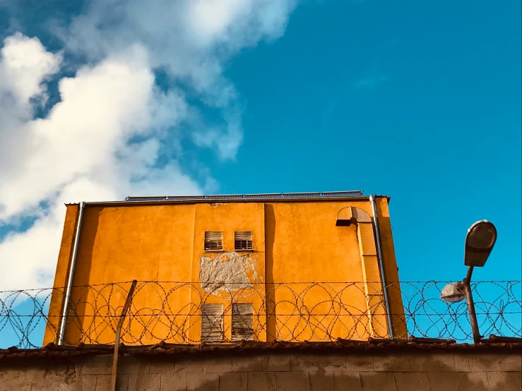 a tall yellow building with a street sign behind it