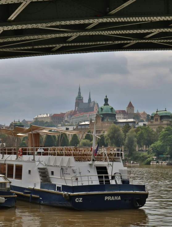 three boats floating in a river under a bridge