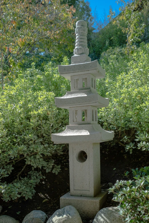 an oriental style birdhouse with small rocks around it