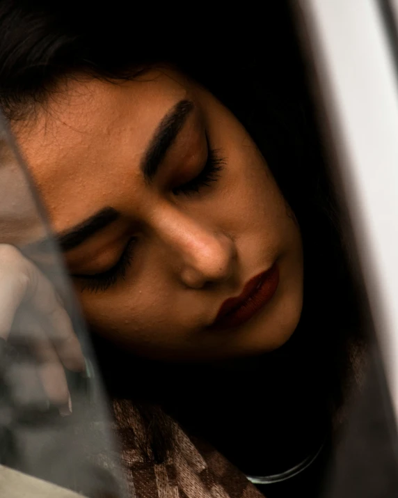 a woman is sleeping on a bus with her eyes closed