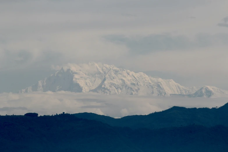 the mountains are covered in clouds and snow