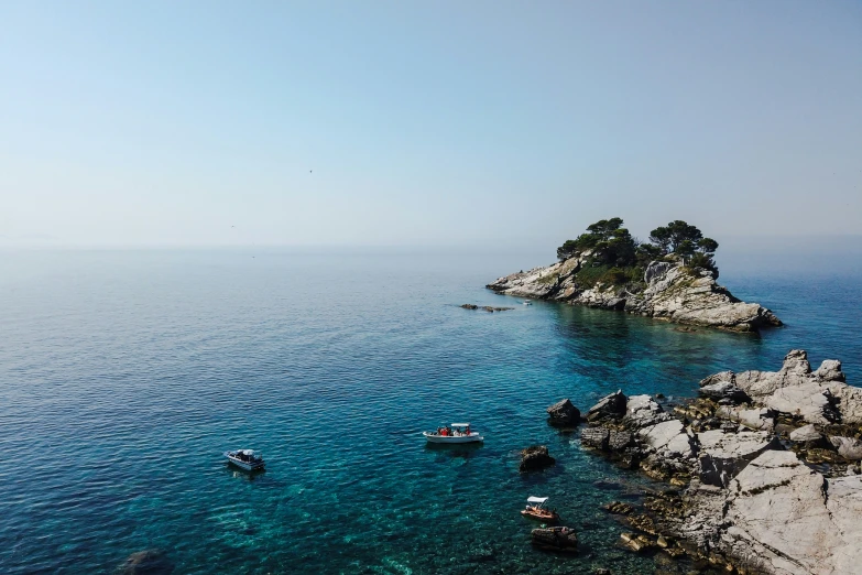 several boats anchored along the shore of the ocean