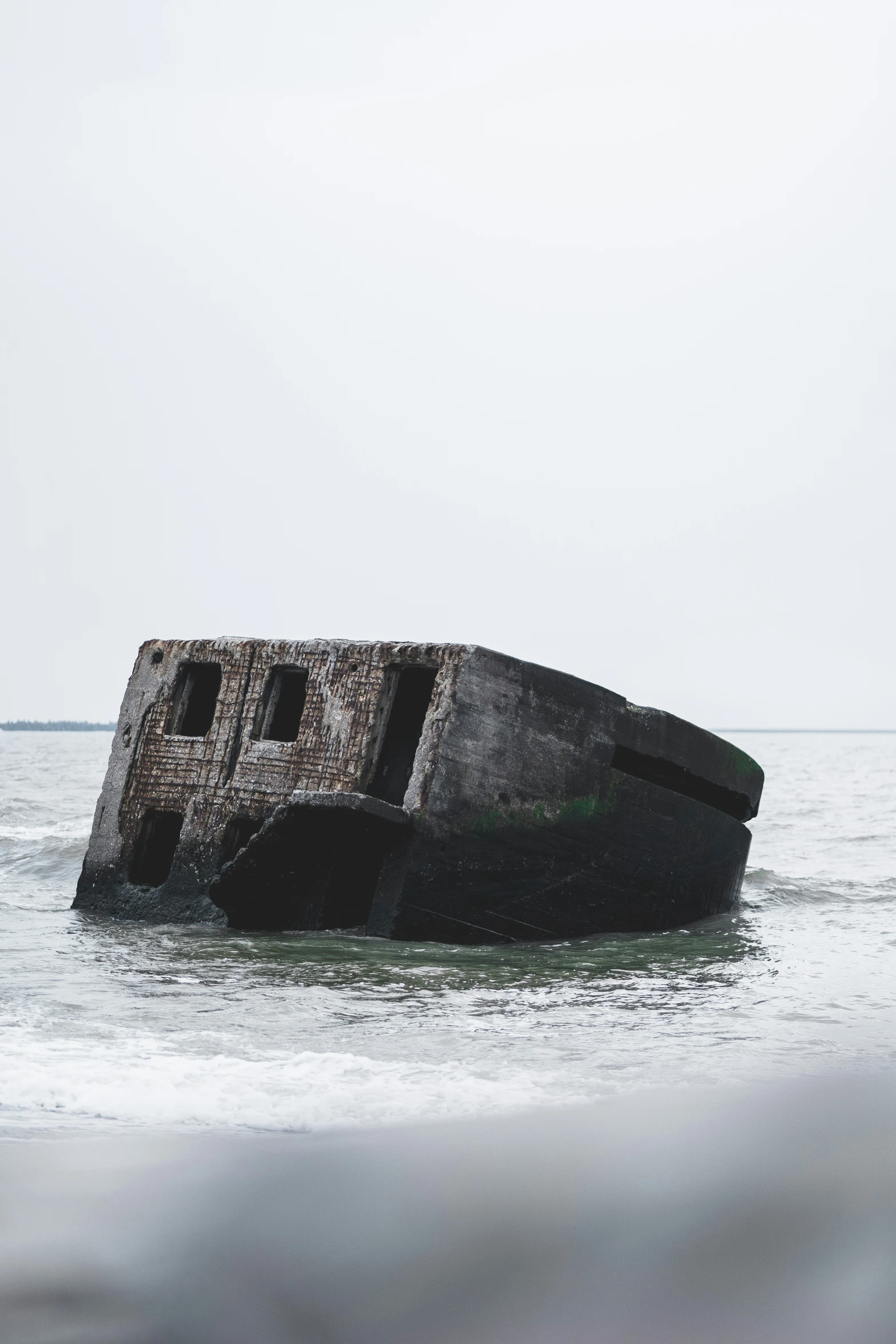 an old rusted out stone boat sits on a body of water