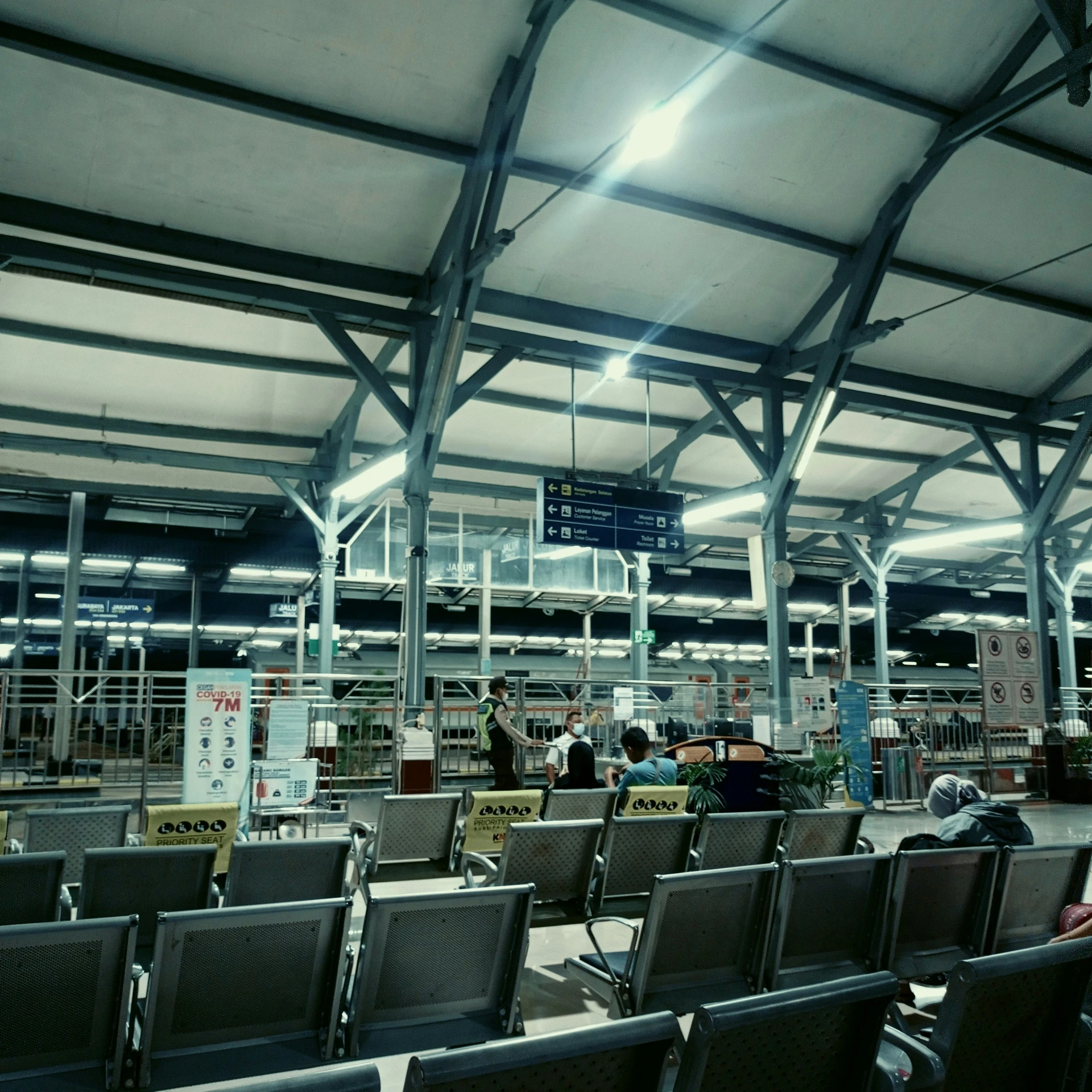 people walking around a airport with many chairs