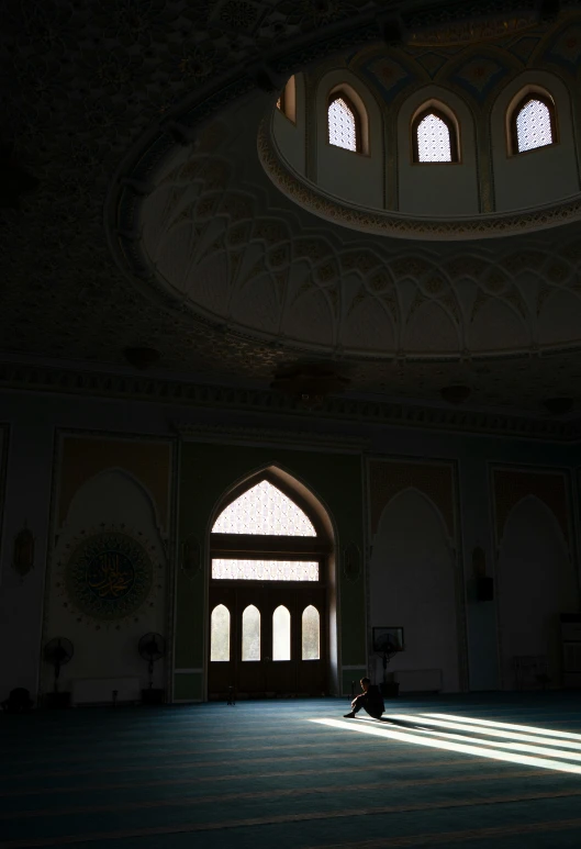 a person sitting on a floor in the middle of an ornate building