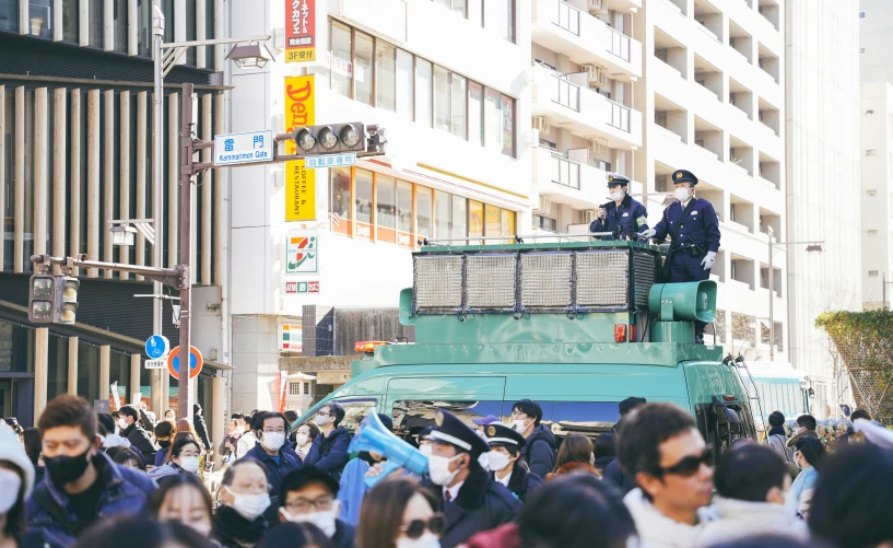 the police stand on top of a vehicle in a crowd