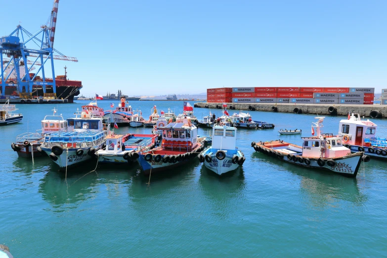 a harbor area with several boats, cranes, and small cranes