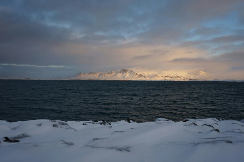 the ocean is clear with snow all over