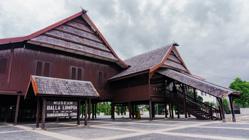 an old wooden building with large windows and stairs on top of it