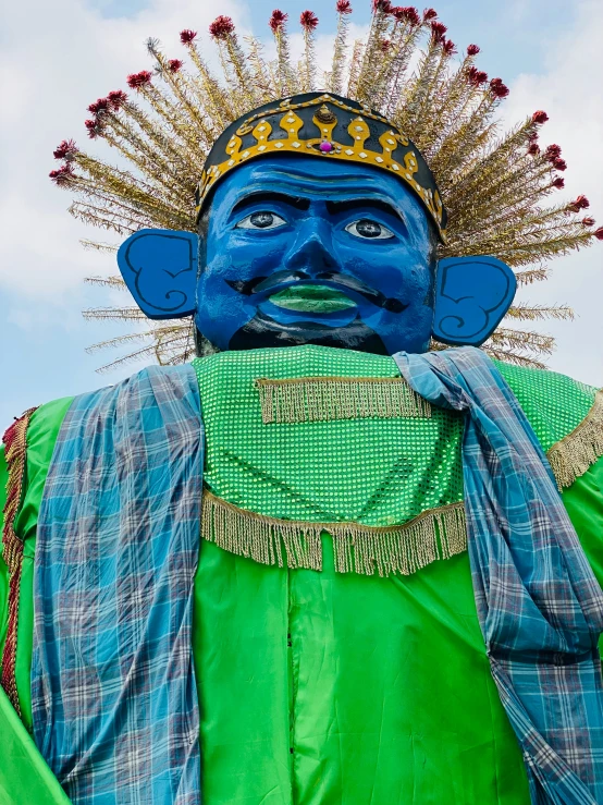 a statue in the shape of a god with blue painted on his face