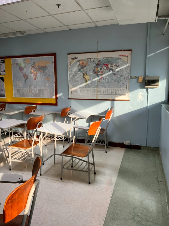 a room with tables, chairs, and a world map hanging on the wall