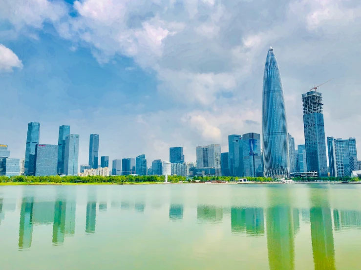 a city with a large lake in front of it and sky reflected