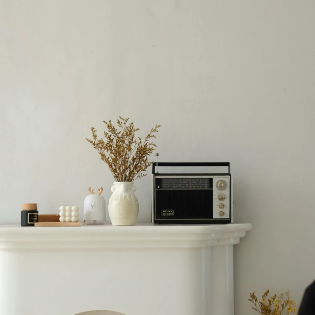 a shelf holding a radio next to a white fireplace