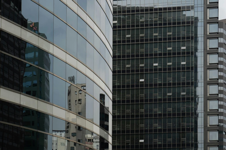 two buildings are reflected in the windows of one of them