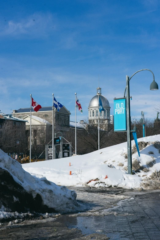 a street sign near a road that is snow covered