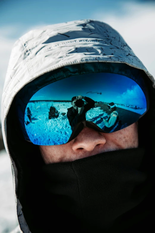 the reflection of snowboarders from the lens of their ski goggles