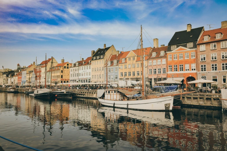 a white boat parked in front of a row of buildings