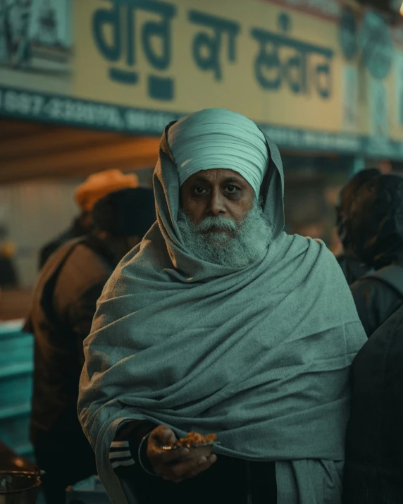 a man with a turban on and holding soing in his hand