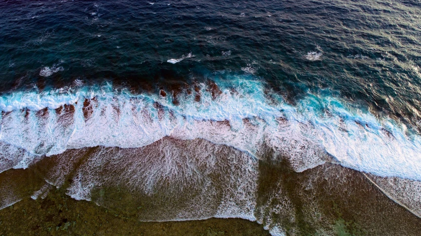 the water is blue with small waves on the shore