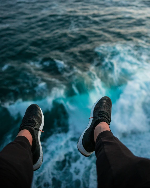 a view of the ocean while feet are in the air