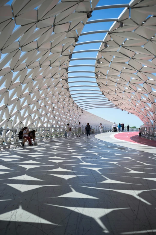 people walk under several different structures in an open area