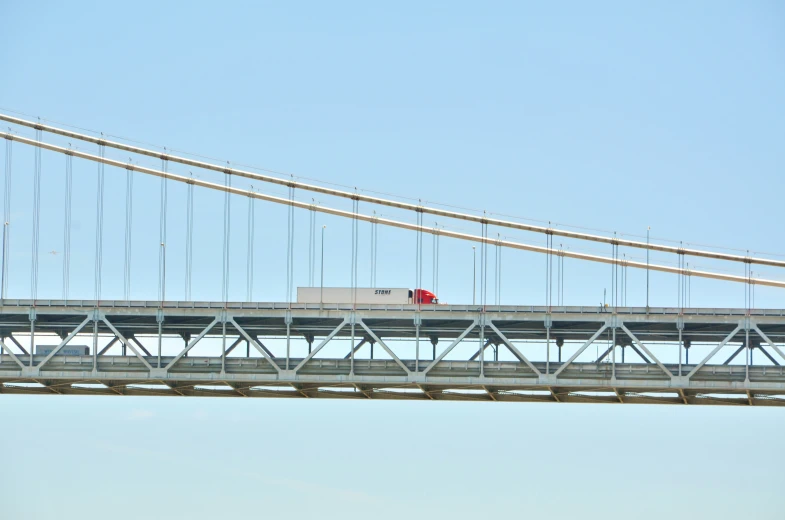 a truck driving over a long bridge on a clear day