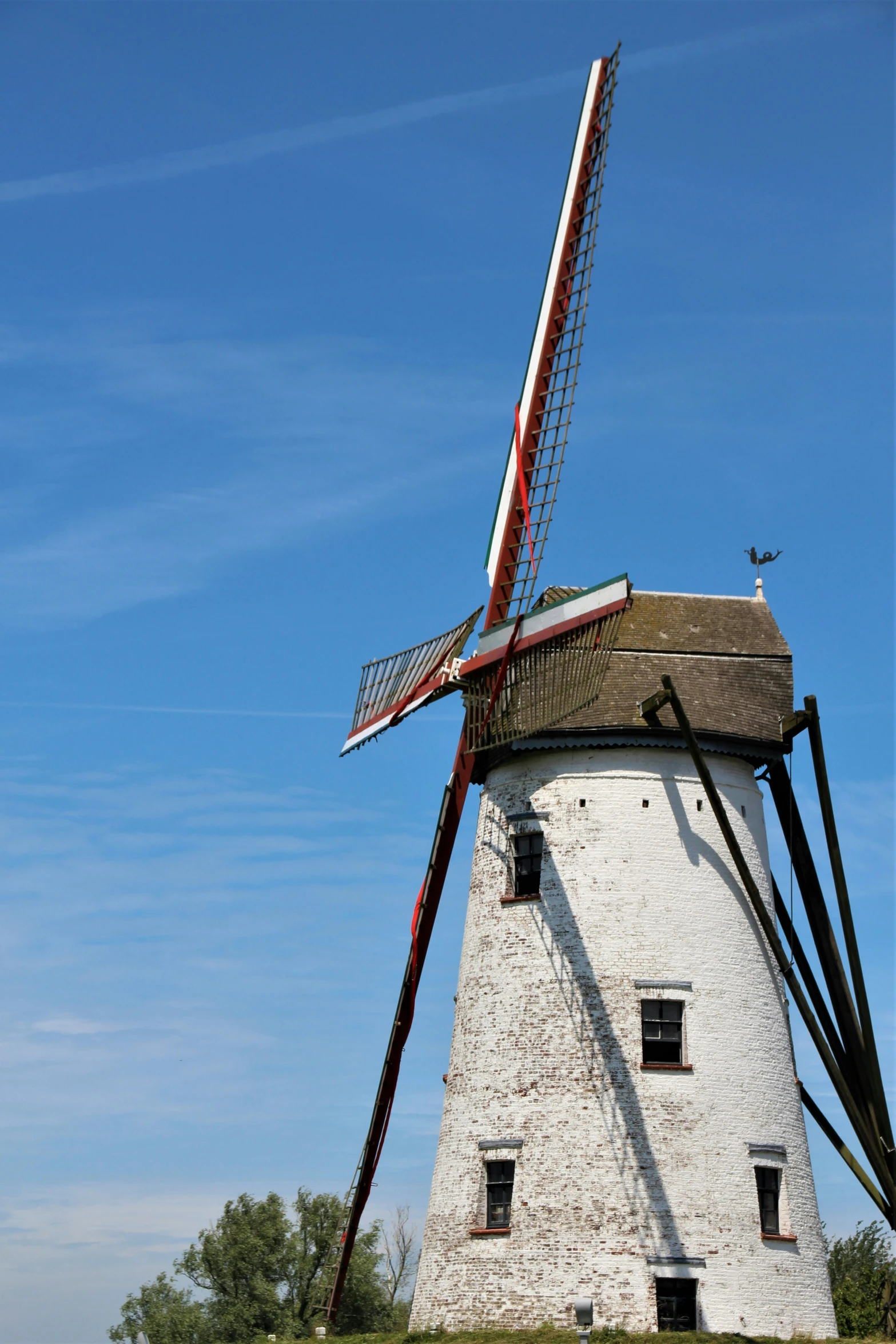 an old windmill sits on top of a hill