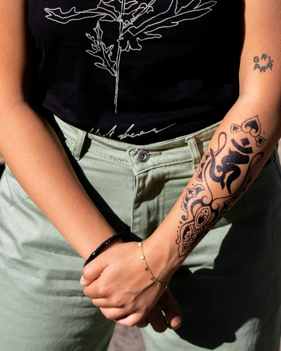 a woman with tattoos on her arm standing on the street