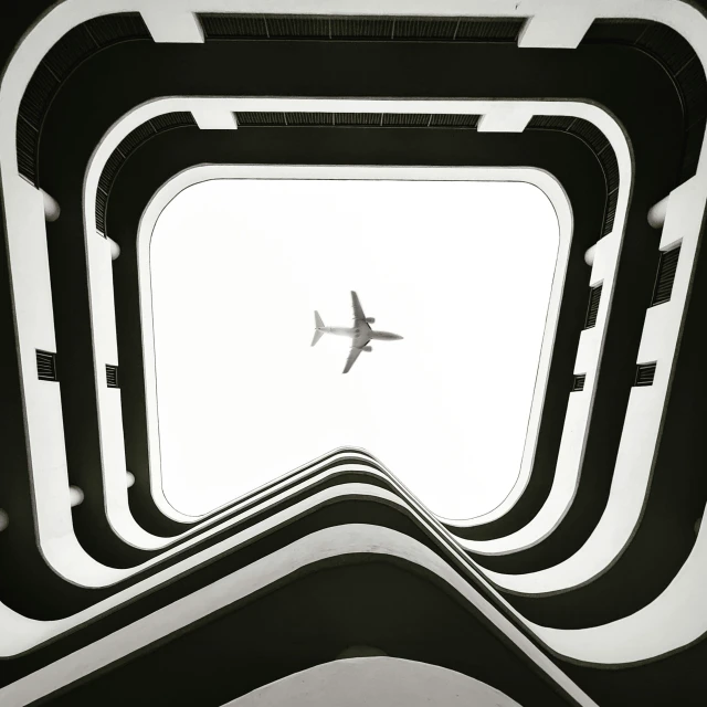 black and white pograph of a plane ascending from underneath