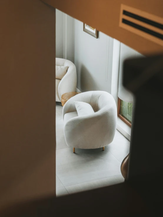 an egg chair with pillows sitting on a floor