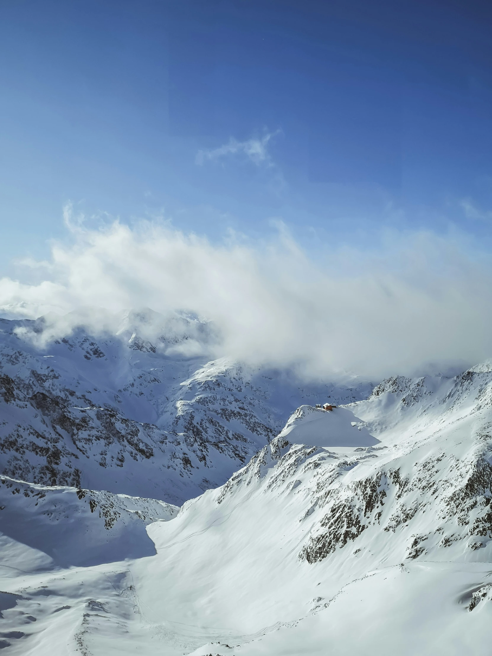 people in skis and snowboards on a snowy mountain