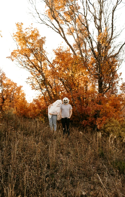 two people in the grass near a tree