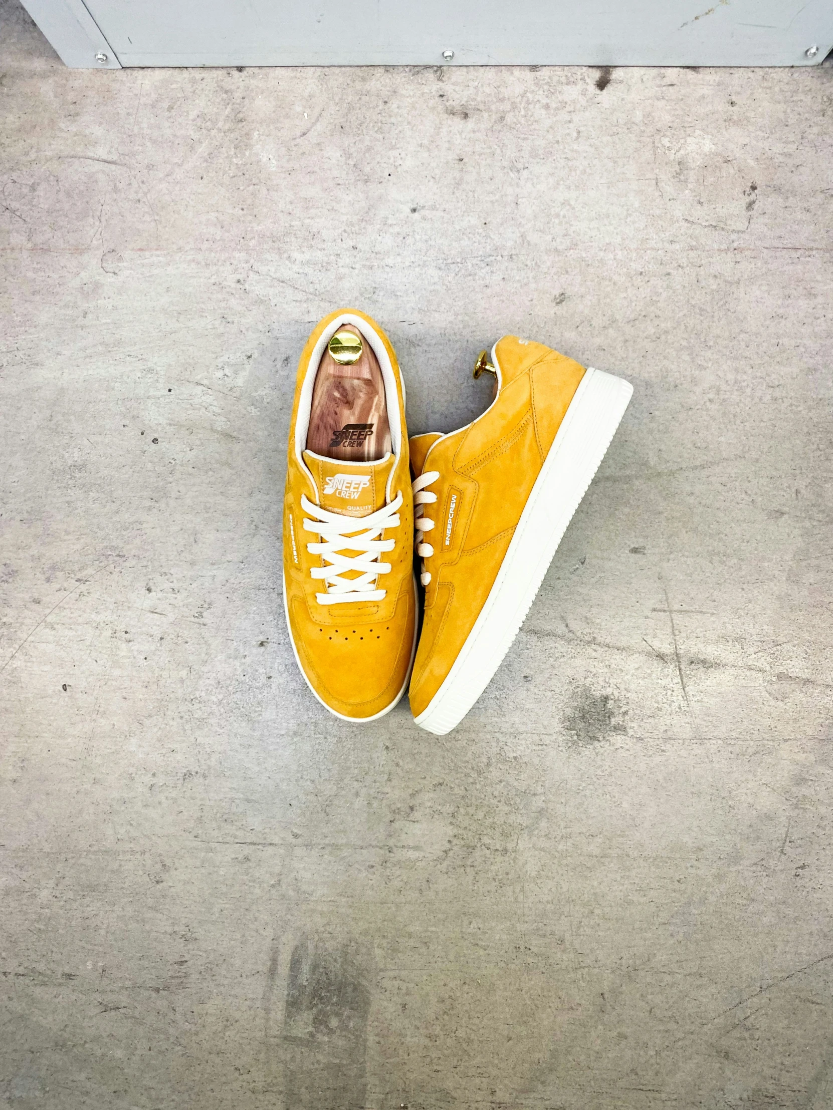 a yellow tennis shoe that has a shoelace in the middle of it