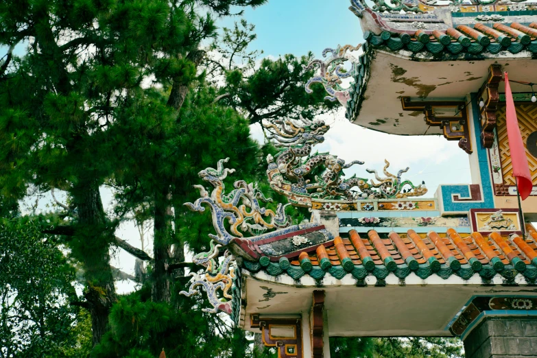 a chinese style roof with a tall pine tree