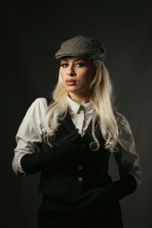 a woman wearing a hat and black dress posing for the camera